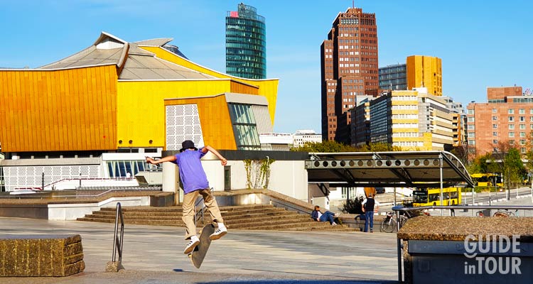 Fra le attrazioni di Berlino non può mancare la Potsdamer Platz. Uin questa foto un gruppo di giovani fanno skate con la piazza più moderna di Berlino in sottofondo.