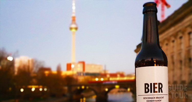 una bottiglia di birra posta sulla spalletta di un ponte di Berlino